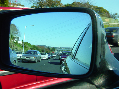 looking at the reflection of traffic through cars wing mirror.