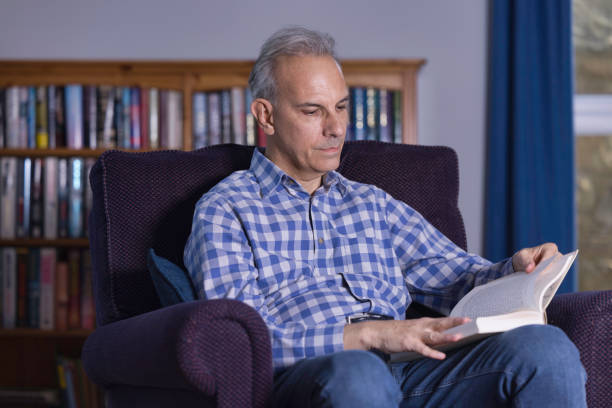 istock Middle-aged man relaxing at home with a book 1392608190