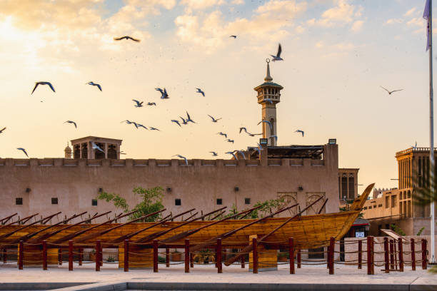закат над районом аль-фахиди в дубае над старой мечетью со многими чайками летать - традиционная восточная культура стоковые фото и изображения