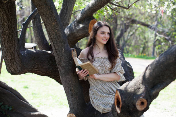 Young woman reading a book at the park