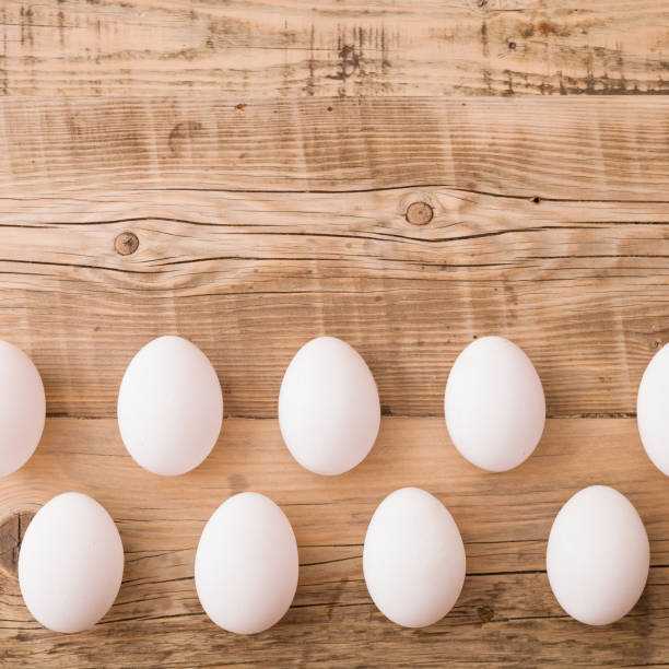 istock Closeup on white eggs lying on a natural wooden background. Easter festive background. 1392618807