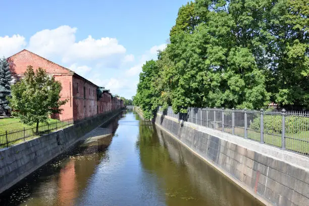 Photo of Kronstadt canal with old building and blue sky background