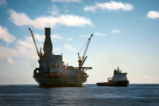 istock Oil rig offshore platform and small support vessel 1392621066