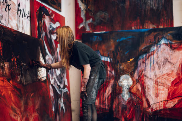 istock Female painter artist painting and creating her art in a creative studio 1392622462