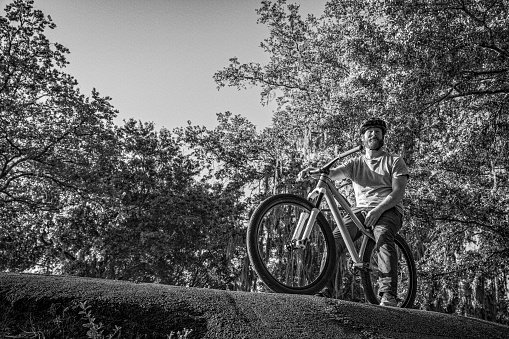 This is a photograph of a man with a beard and red hair on a mountain bike on a sunny outdoor morning in Orlando Florida