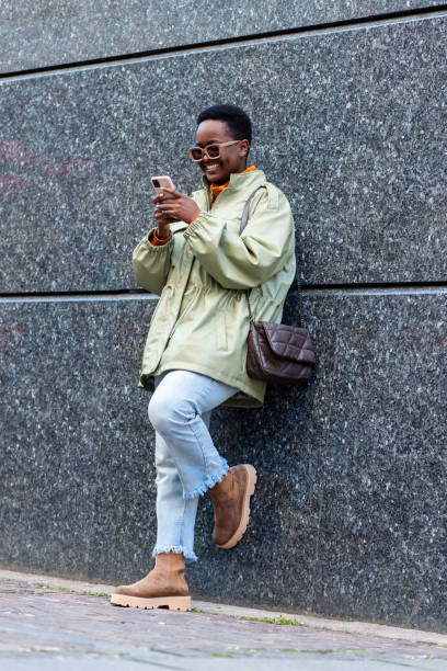 istock Attractive black businesswoman using phone outside 1392624220