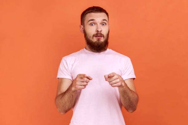 istock Man looking with big eyes and open mouth, pointing finger at camera, suspecting you. 1392626122