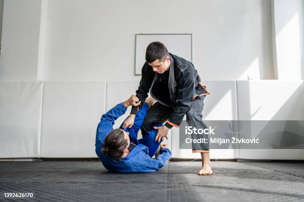 Two Brazilian Jiu Jitsu Bjj Athletes Training At The Academy Martial Arts Ground Fighting Sparring Wear Kimono Gi Sport Uniform On The Tatami Mats Sports Jiujitsu And Selfdefense Concept Copy Space Stock Photo - Download Image Now