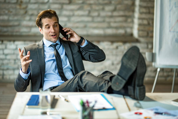 istock Happy businessman talking on phone while relaxing in the office. 1392626438