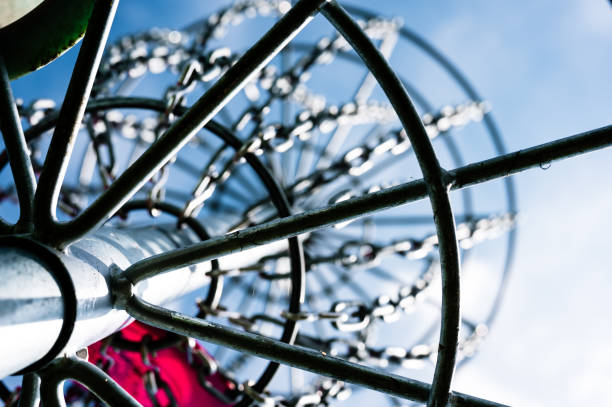 istock Underneath a disc golf goal looking up with selective focus on the chain basket. 1392632116