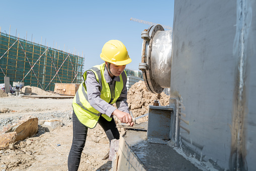 The female cement worker builds cement on the construction site