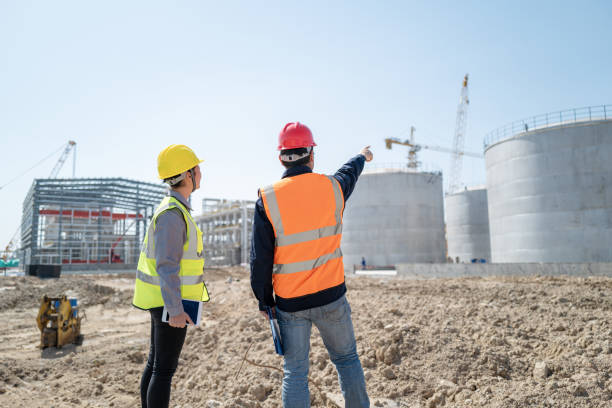 istock Male and female engineers back to the camera to guide the work on the construction site 1392633721