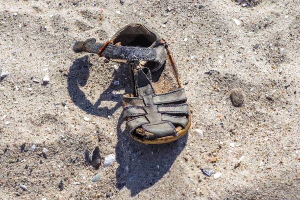 istock Old vintage shoe on a sandy beach. 1392633851
