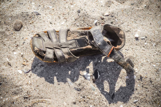 istock Old vintage shoe on a sandy beach. 1392633870