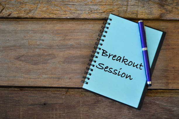 Notebook written with text BREAKOUT SESSION over wooden background. Top view of pen and notebook written with BREAKOUT SESSION. escaping stock pictures, royalty-free photos & images