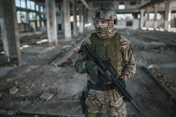 istock Armed soldier in camouflage uniform on patrol in war zone 1392643937