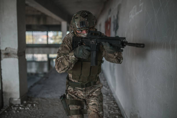 istock Special forces soldier aiming with weapon in battle in war zone 1392648622