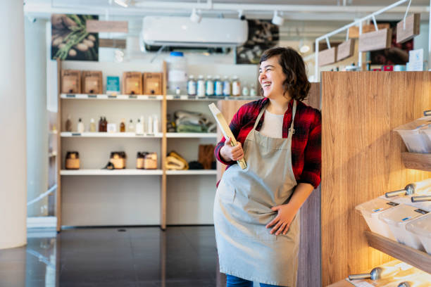 istock Young female entrepreneur laughing while standing in zero waste market 1392648995