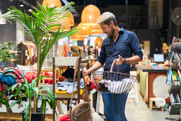 homme latino-américain faisant ses courses dans un magasin de vêtements - boutique store owner latin american and hispanic ethnicity photos et images de collection