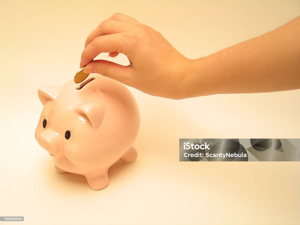 Pink piggy 4 Hand about to drop a coin into the pink piggy bank. Child Stock Photo