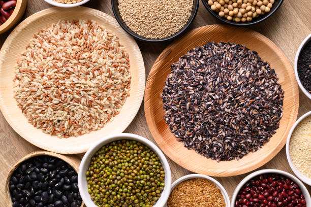 various cereal, grain, bean, legume and seed in bowl on wooden background - dishware brown rice rice variation imagens e fotografias de stock