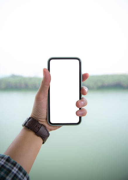 istock People holding a moblie in the park 1392655769