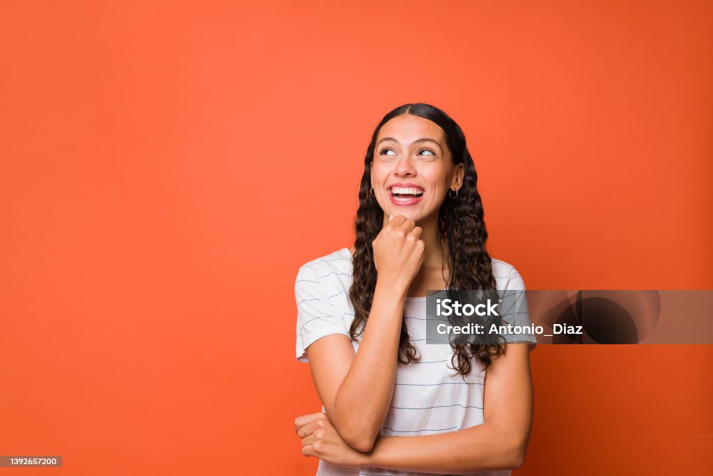 Smiling woman dreaming about the future Thoughtful young woman looking up and using her imagination while thinking about new ideas Looking Up Stock Photo
