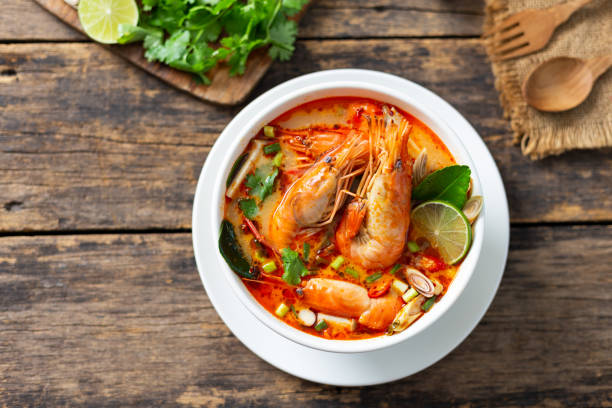 tom yam kung ,prawn and lemon soup with mushrooms, thai food in wooden bowl top view - sopa tom yum imagens e fotografias de stock
