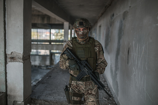 Special forces soldier wearing camouflage uniform armed with weapons in conflict war zone