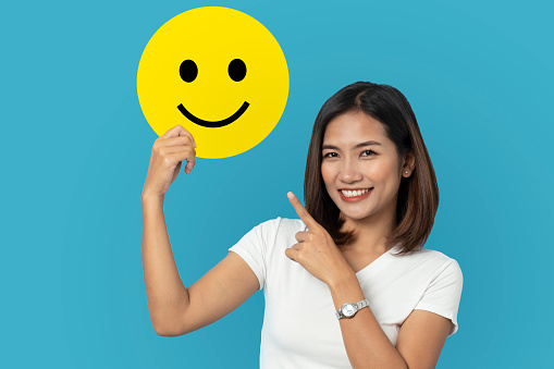 Customer experience concept, cheerful young woman Raise a speech bubble with a smiley face. Critique her experience for a happy satisfaction survey.