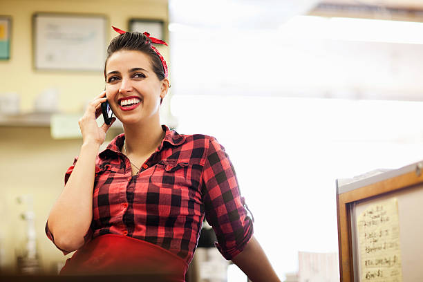 jovem mulher tendo uma chamada de telefone em padaria - baker california - fotografias e filmes do acervo