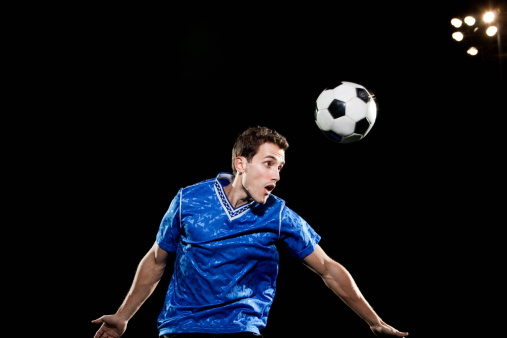 Hombre joven del salto del forma de pelota de fútbol photo