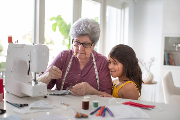Grandma teaching granddaughter how to sew