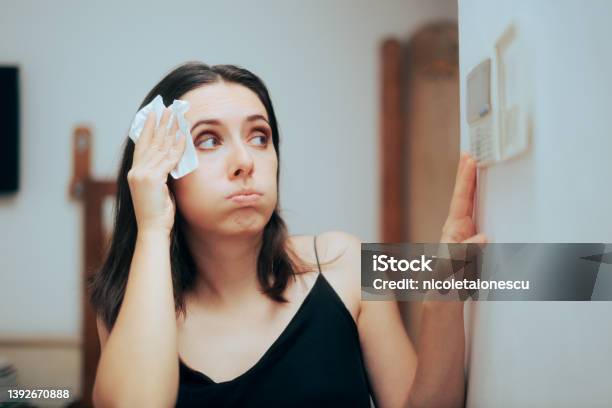 Woman Felling Hot During Summer Setting Her Thermostat Stock Photo - Download Image Now