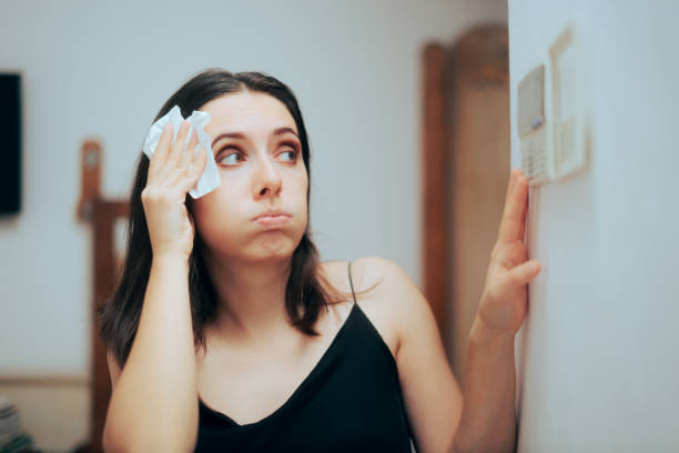 mulher caindo quente durante o verão definindo seu termostato - ventilador - fotografias e filmes do acervo
