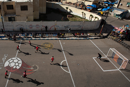 Alexandria, Egypt- 20 April: A football game on the street, from the Al-Flaky Zone cup to be held during the holy month of Ramadan every year It had stopped since the Coronavirus pandemic.
