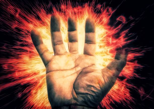 Close-up on a hand holding a fireball isolated on a black background.