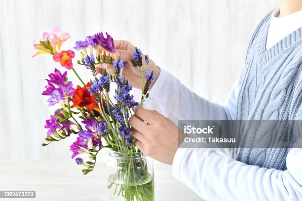 リビングルームで花を並べる女性の手