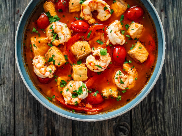 istock Fish soup with prawns and tomatoes on wooden table 1392677829