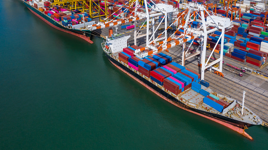 Aerial view container ship at commercial dock, Company import export  global business trade logistic and transportation by container cargo ship boat, Freight shipping maritime sea port terminal.
