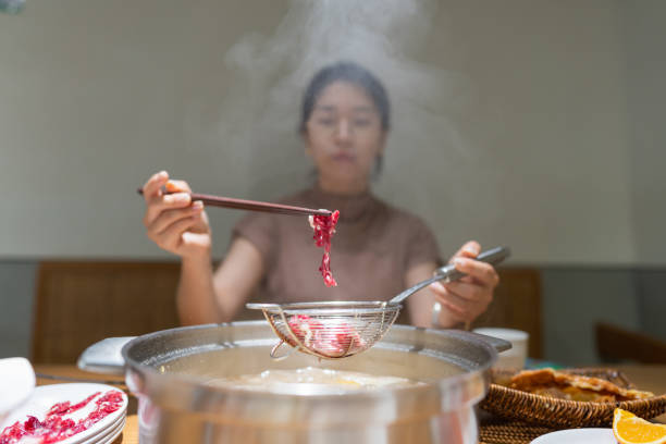 istock Asian woman holding beef with chopsticks 1392680144