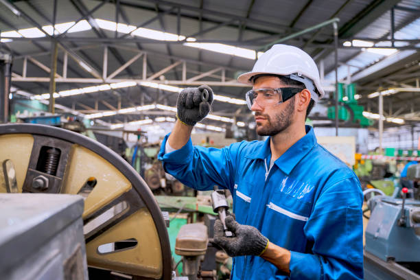 istock Blue collar worker with co worker at factory. 1392685233
