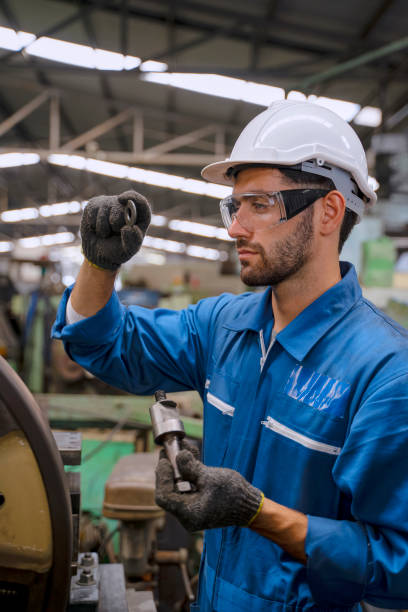 istock Blue collar worker with co worker at factory. 1392685236