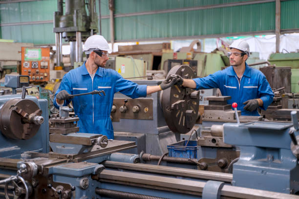 istock Blue collar worker with co worker at factory. 1392685255