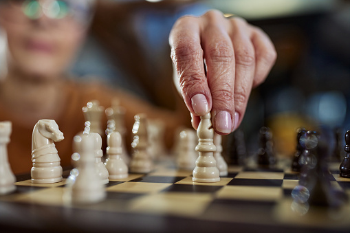 Close up of unrecognizable senior woman playing chess.