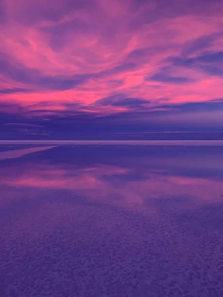 istock Purple pink sunset sky clouds over the sea. 1392690973