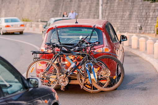 A car loaded with bicycles rides along the road.