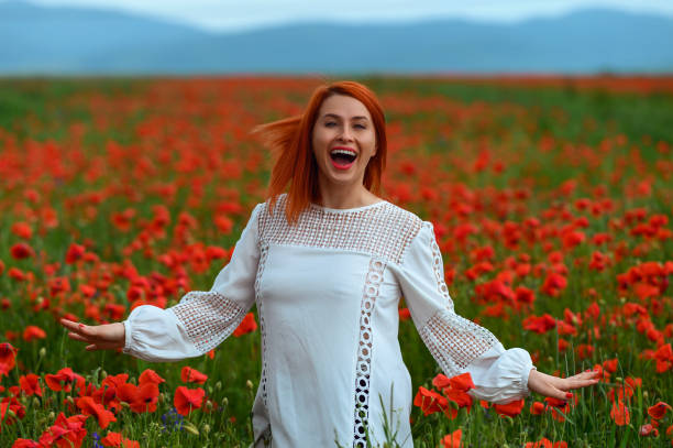 istock Cheerful lady in poppies field 1392691918