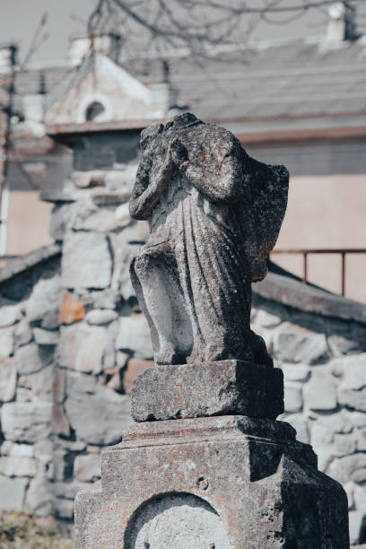 escultura de ángel de piedra decapitada en un antiguo cementerio abandonado. cementerio olvidado, tumba desconocida. enfoque selectivo. imagen vertical. vandalismo en el antiguo cementerio - sculpture gothic style grave spooky fotografías e imágenes de stock