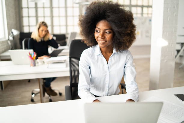 istock Bright modern office, with women working at desks 1392698631